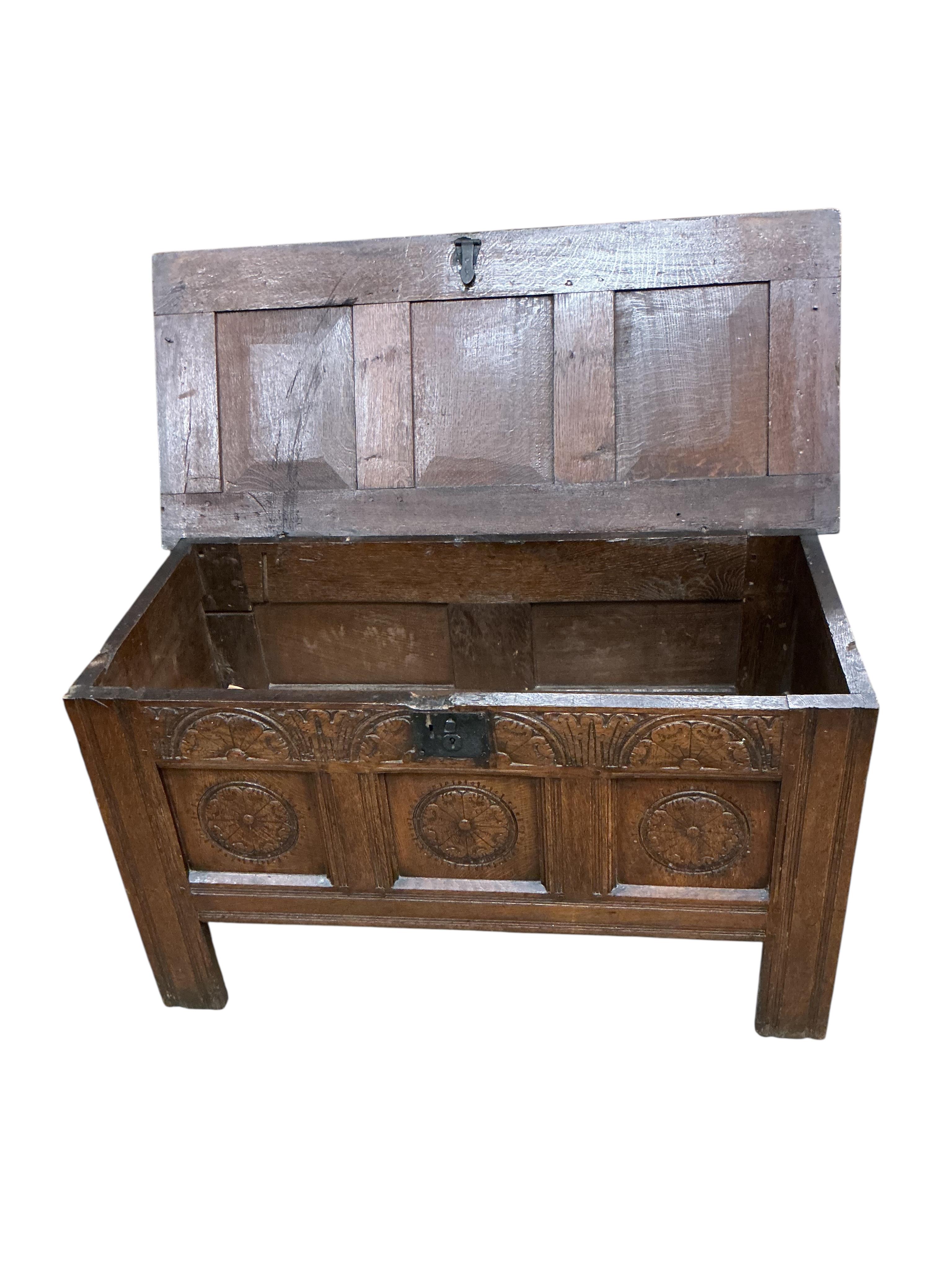 An oak coffer with three panels carved with roundels, width 106cm, depth 47cm, height 61cm